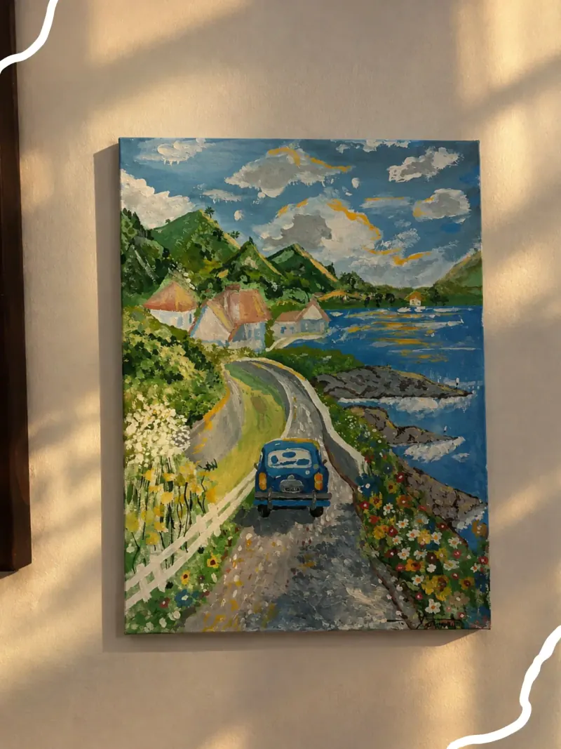 Tela pintada à mão de uma estrada costeira com um fusca azul, montanhas e flores