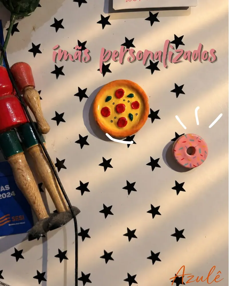 Dois ímãs de cerâmica fria, uma pizza e uma rosquinha, sobre tecido de estrelas